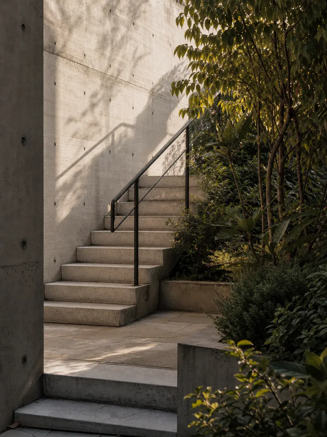 Escalera exterior de concreto junto a un jardín residencial